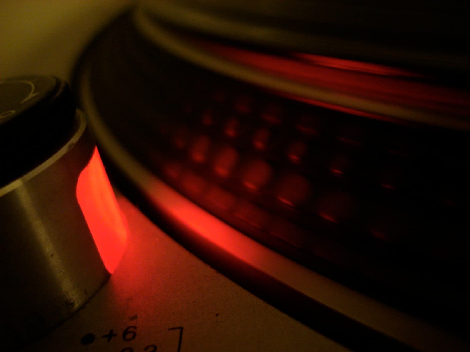 The red strobe lamp lighting the platter dots on a Technics SL-1200-series deck.