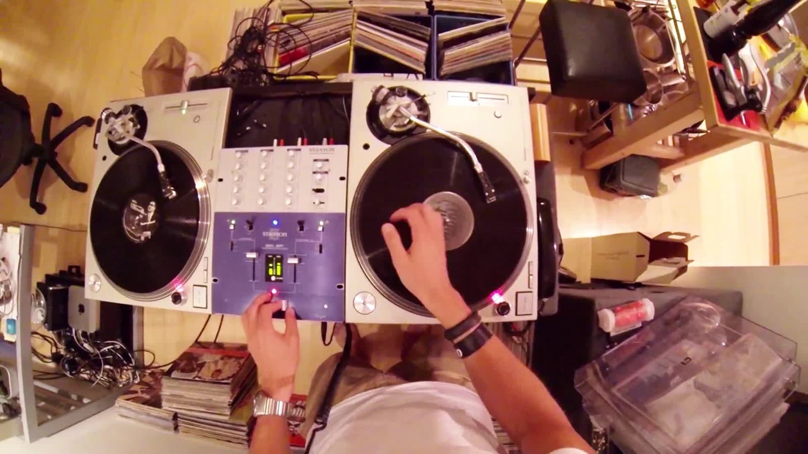 A pair of silver SL-1200M3Ds with a Stanton mixer, seen from above mid-scratch